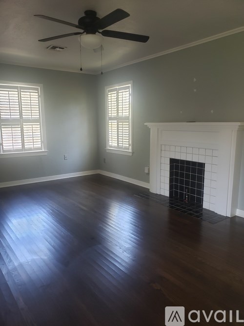 A room with a fireplace and a ceiling fan.