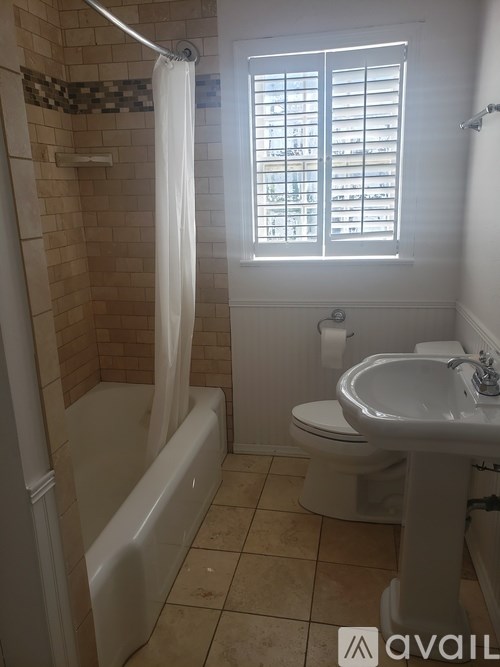 A bathroom with a white toilet, sink, and bathtub.
