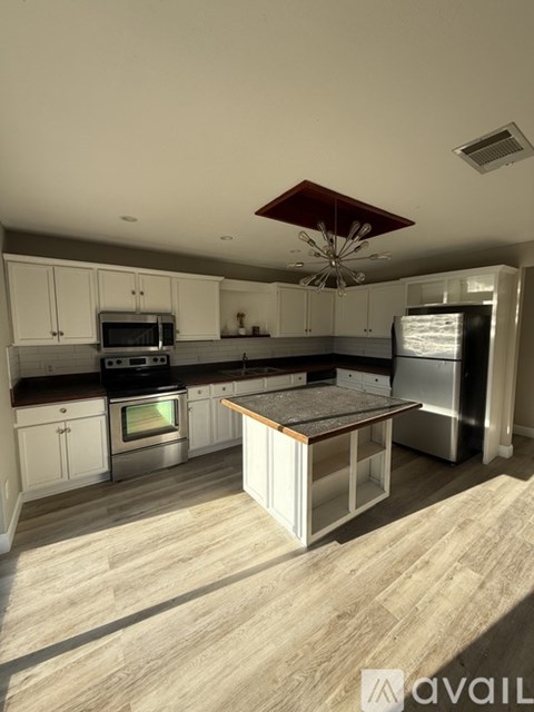 A kitchen with a wooden floor and a central island.