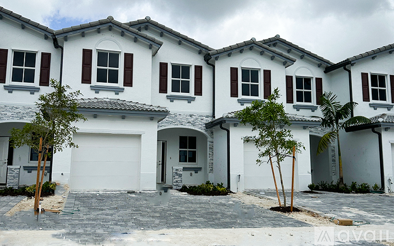 A row of white houses with brown shutters.