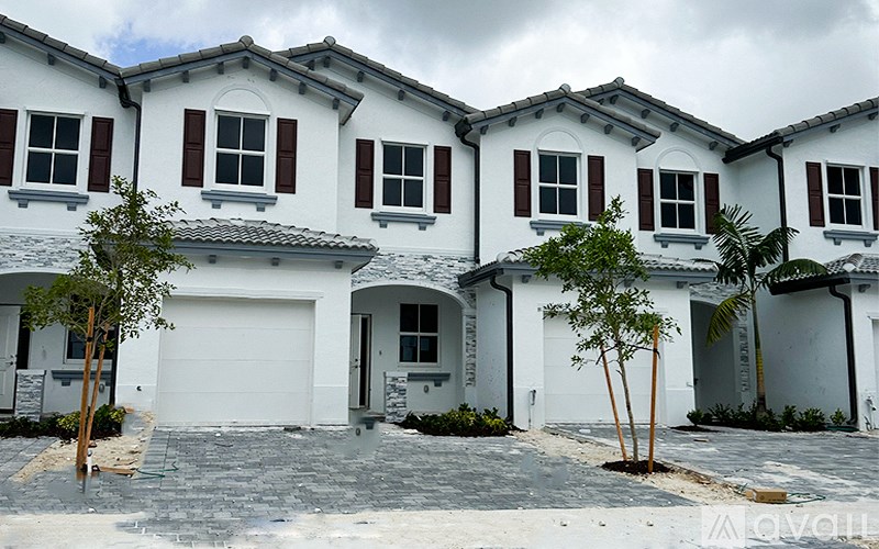 A row of white houses with brown shutters.