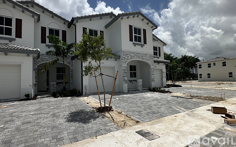 A row of houses with a tree in the middle of the driveway.