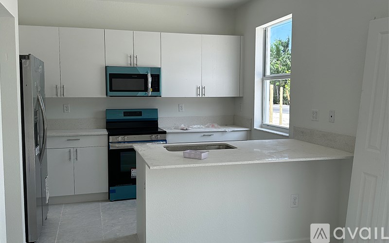 A kitchen with white cabinets and a blue oven.