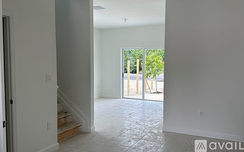 A room with a tiled floor and a door leading to a balcony.