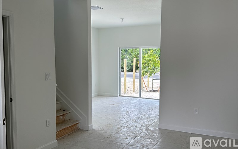 A room with a tiled floor and a door leading to a balcony.
