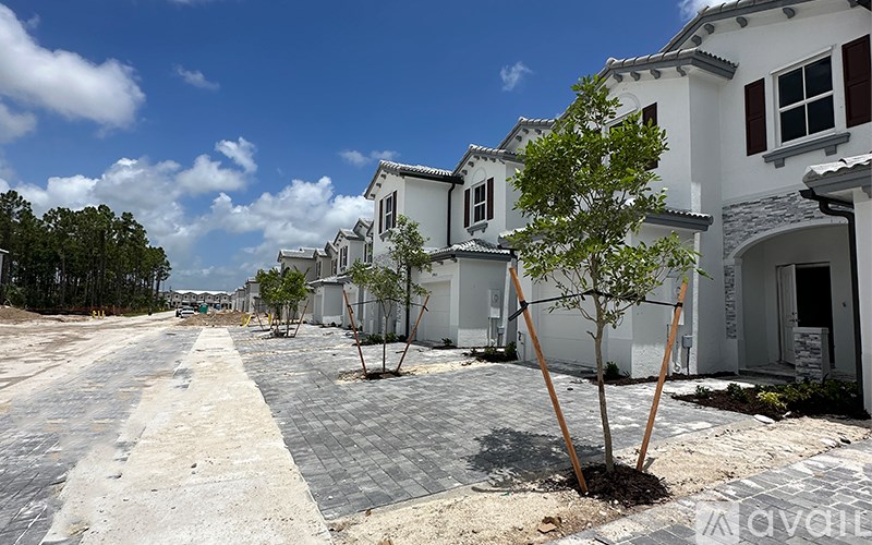 A row of houses with trees in front of them.