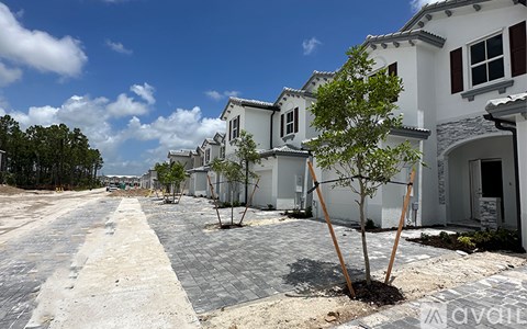 A row of houses with trees in front of them.