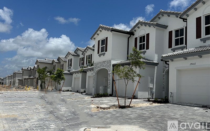 A row of houses with a cobblestone street in front.