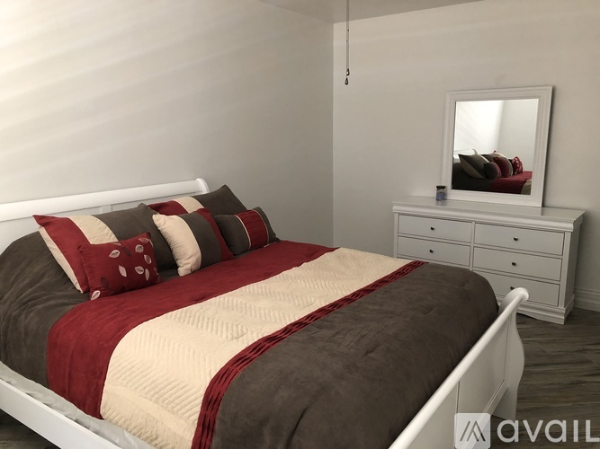 A bedroom with a bed, nightstand, and a mirror.