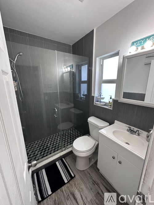 A bathroom with a toilet, sink, and shower.