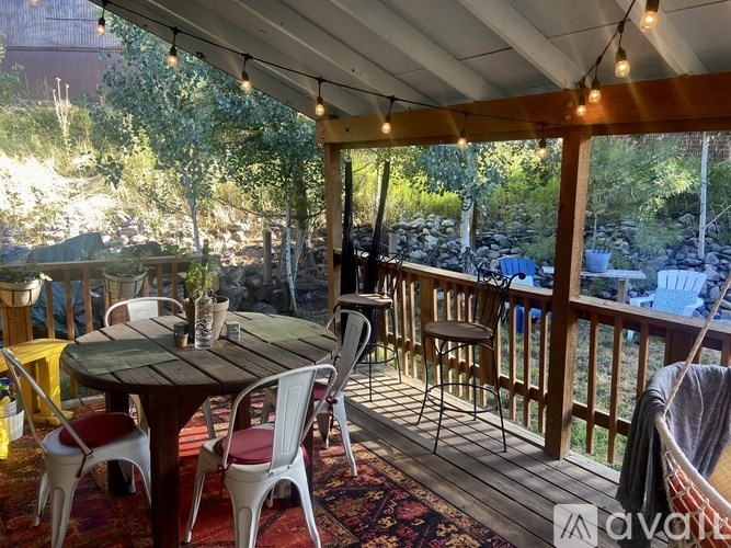 A patio with a table and chairs is set up on a deck.