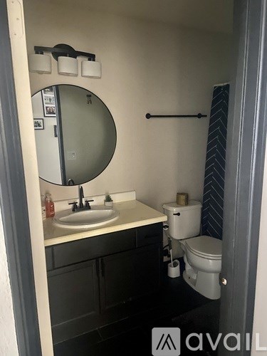 A bathroom with a sink, mirror, toilet and a towel rack.