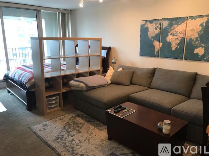 A living room with a grey couch, a coffee table, and a world map on the wall.
