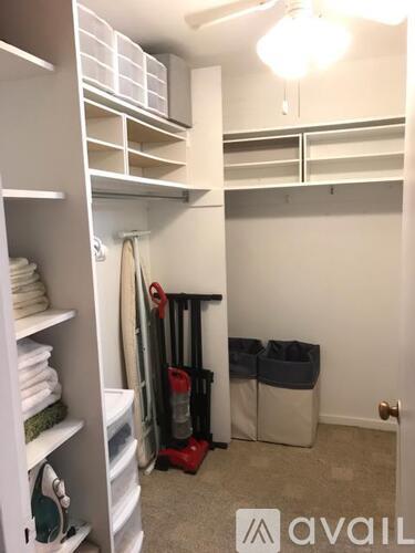 A room with a white closet and a red vacuum cleaner.