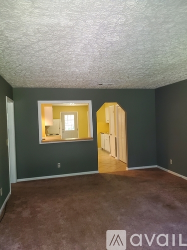A room with a carpeted floor and a window.