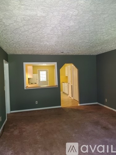 A room with a carpeted floor and a window.