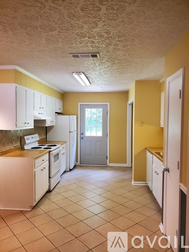 A kitchen with yellow walls and white appliances.