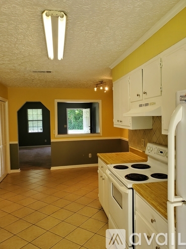 A kitchen with yellow walls and white appliances.