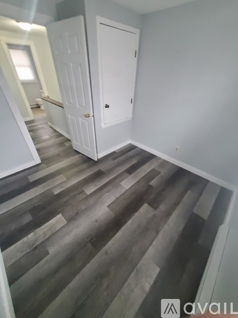 A room with a wooden floor and a white door.