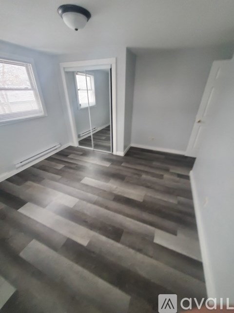 A room with a wooden floor and a white door.