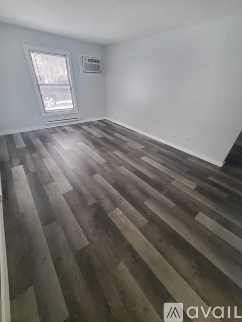 A room with wooden flooring and a window.
