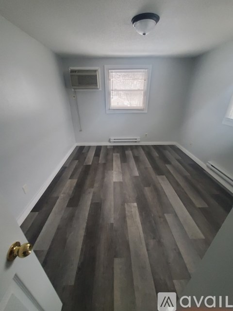 A room with wooden flooring and a window.