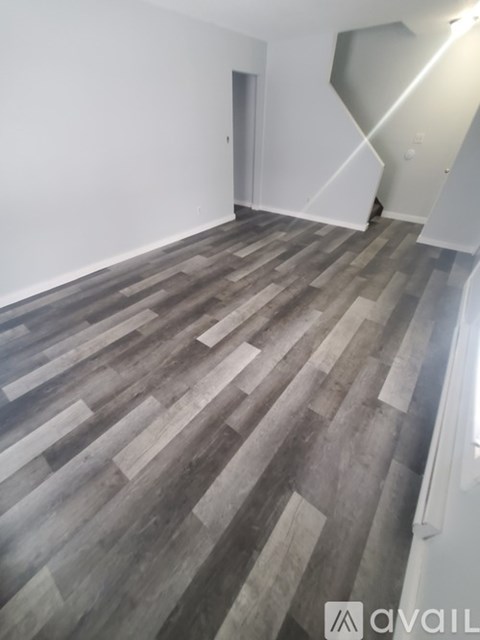 A room with wooden flooring and a staircase.