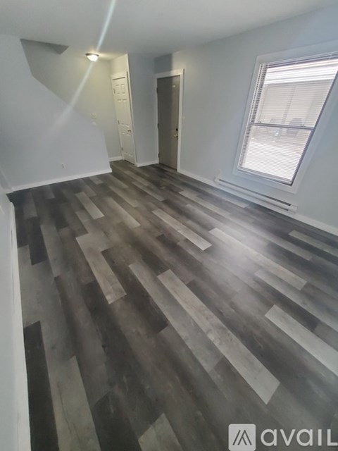 A room with a wooden floor and a window.