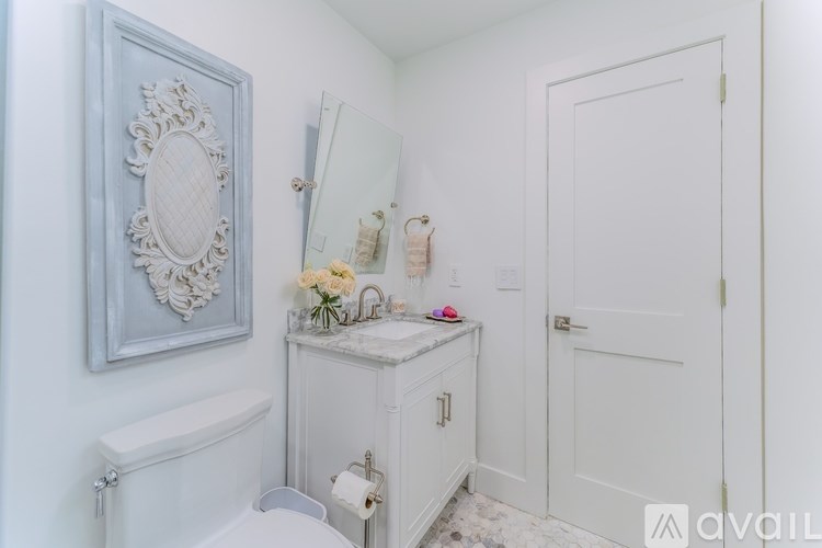 A bathroom with a white sink and a mirror above it.