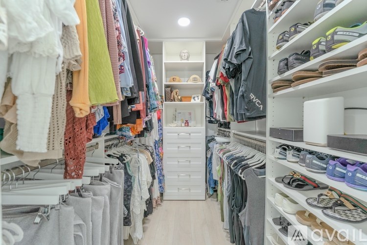 A well-organized walk-in closet with neatly arranged clothes and shoes.