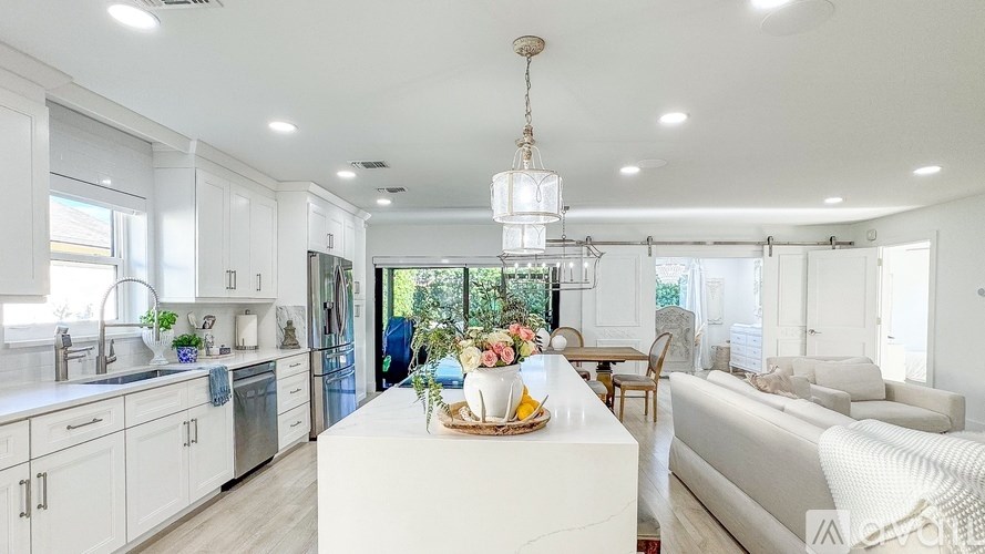 A modern kitchen with white cabinets and a large island in the middle.