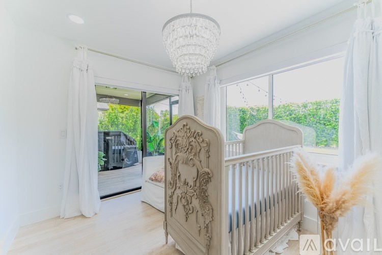 A baby's room with a white crib and a chandelier.