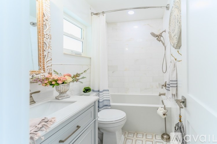 A bathroom with a toilet, sink, and shower.