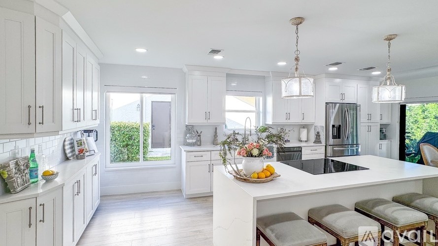 A modern kitchen with white cabinets and a central island.
