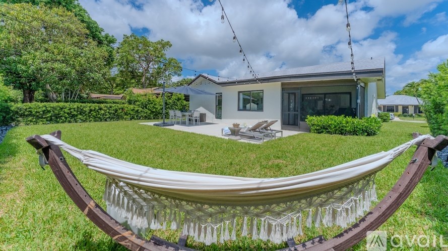 A hammock is strung between two wooden posts in a grassy area.