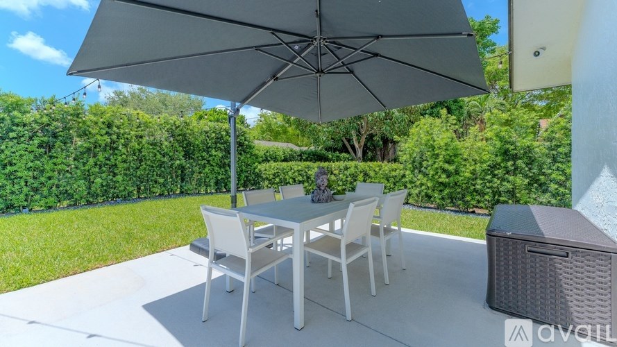 A patio with a table and chairs under an umbrella.