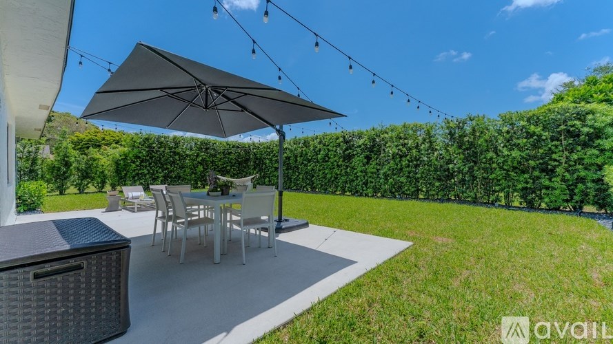 A patio with a table and chairs under an umbrella.