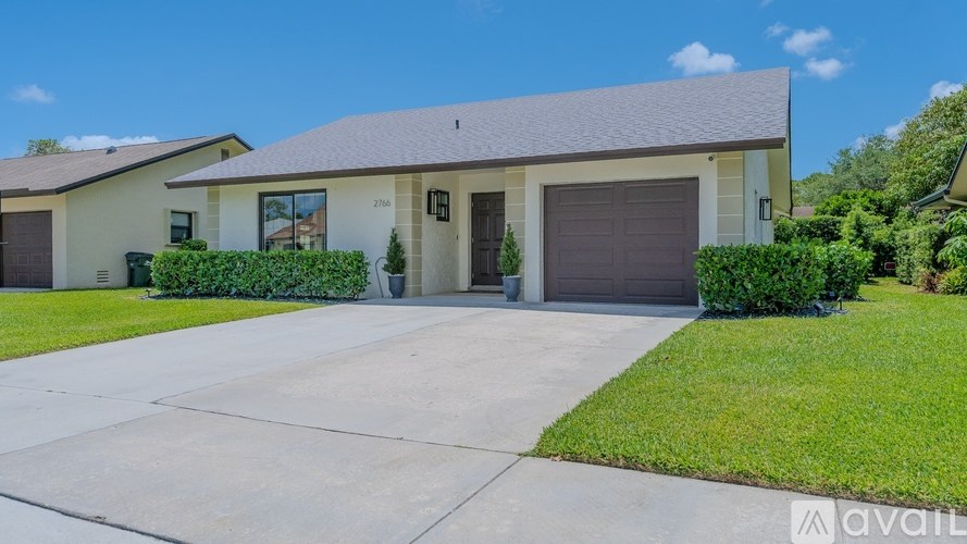 A house with a garage and a driveway in front.