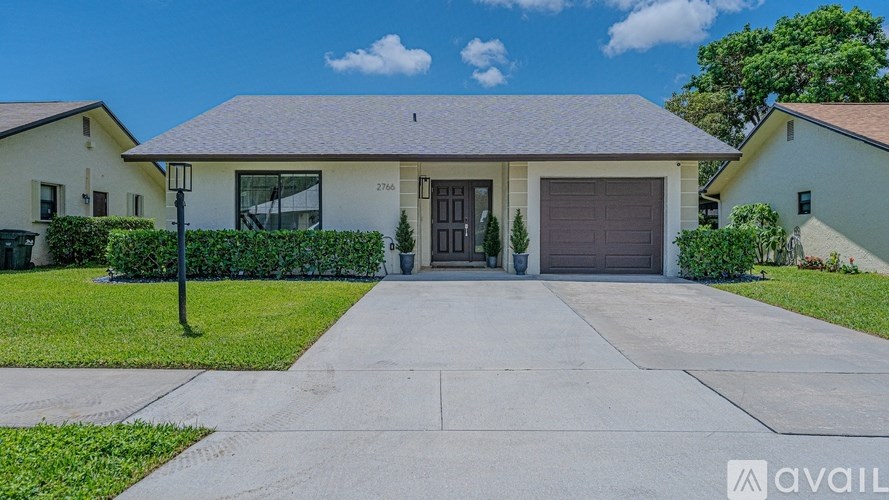 A house with a garage and a driveway is available for sale.