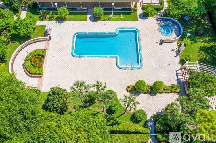 An aerial view of a swimming pool surrounded by a well-manicured garden.