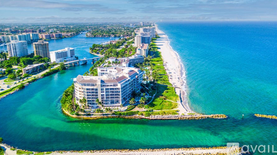 A large white building sits on a small island in the middle of a body of water.