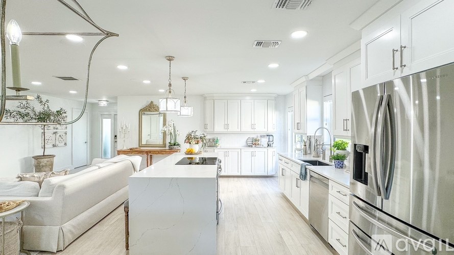 A modern kitchen with stainless steel appliances and white cabinetry.