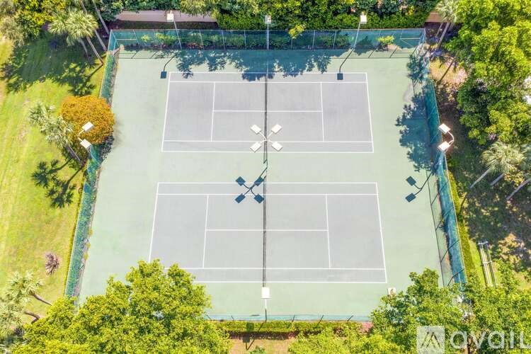 An aerial view of a tennis court surrounded by trees.