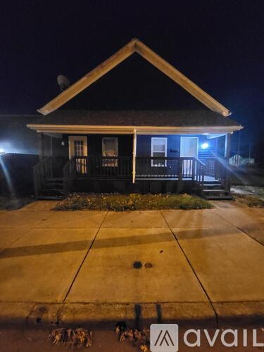 A house with a porch and a lit blue door.