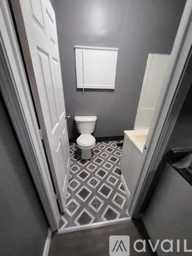 A bathroom with a toilet and a tiled floor.