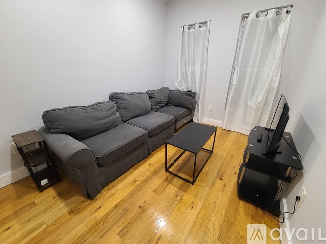 A grey sectional sofa with a black coffee table in front of it.