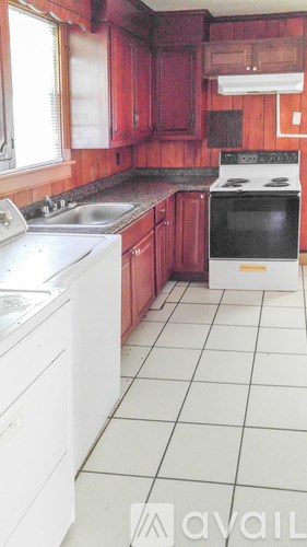 A kitchen with red cabinets and white appliances.