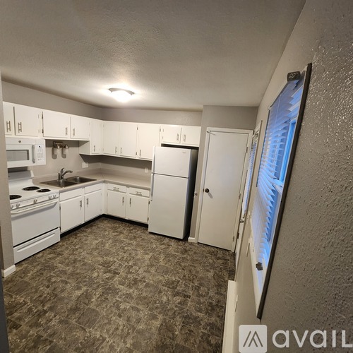 A kitchen with white appliances and cabinets.