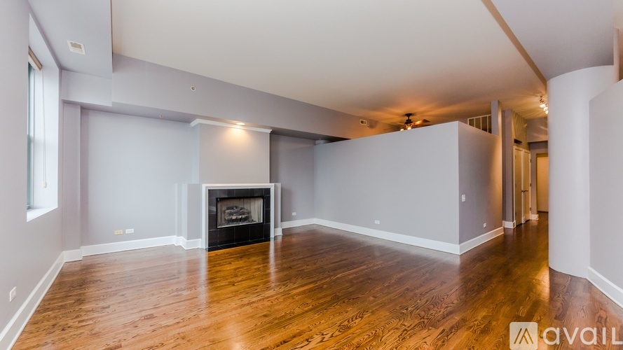 A spacious living room with a fireplace and hardwood floors.