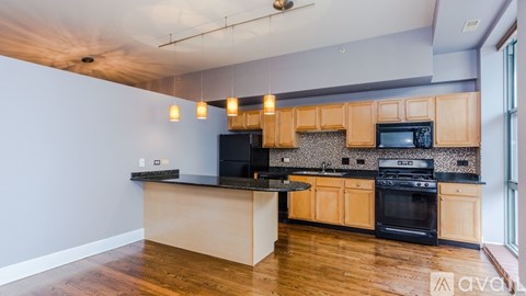 A kitchen with wooden cabinets and black appliances.